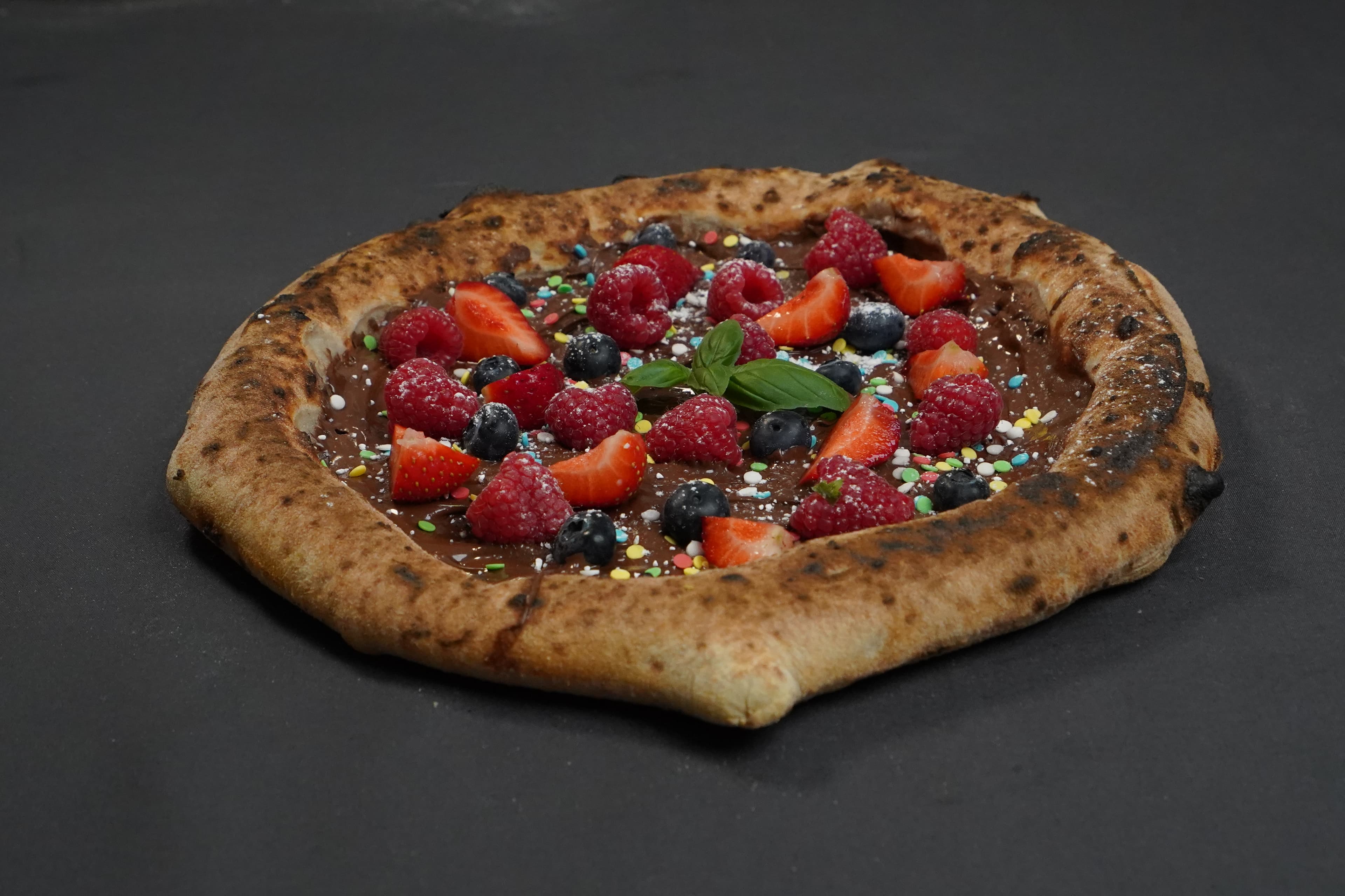 Süße Pizza mit Waldfrüchten und Nutella